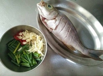 step1: 黃雞魚【澎湖野生水產】泡冷水解凍，並將黃雞魚【澎湖野生水產】清洗乾淨，去魚鱗、魚鰓、內臟，並抹上少許的塩，辣椒斜切，薑切絲，蒜頭切碎，青蔥切段，備用；