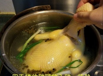 step3: 用手揸住雞頸放入雞，待熱水灌滿雞肚再提起雞倒出熱水，重覆此動作3次，待水再滾起後，蓋上煲蓋熄火焗45分鐘