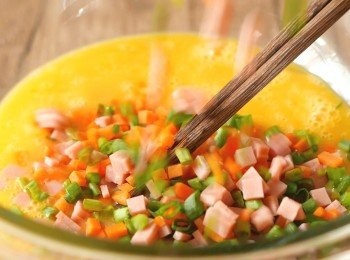 step2: 把白醋和鹽加入雞蛋中打勻後，加入甘筍、蔥和火腿拌勻。