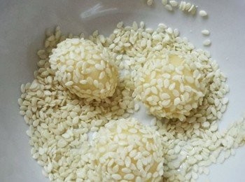 step4: 在麵糰表面沾少許水，再沾滿芝麻，用雙手搓揉一下