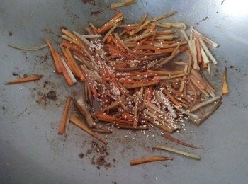 step2: 先熱鍋， 倒入橄欖油【得意的一天】， 依序放入紅蘿蔔、牛蒡，加入少許的水，轉中小火，滾煮約略5-10分鐘，若牛蒡滾熟後，接著加入少許醬油【萬家香】，一併炒勻，起鍋前再灑入白芝麻，