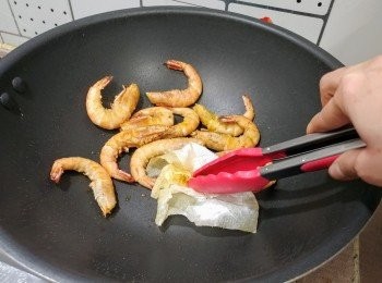 step7: 把廚紙投入鑊中， 用夾幫助吸去鑊中的多餘油分， 令蝦變得乾身