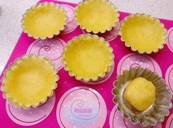 step6: 將小麵糰放喺已掃油的撻模中間，用指腹輕力向四周壓開，直到可以覆蓋整個模，盡量厚薄均衡一點。