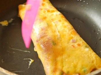 step4: 在鍋中多抹一點油，把蛋捲移到開始捲的位置，在剛剛沒有多抹油的地方再抹一下油。加入一半剩餘的蛋漿，小心掀起蛋捲，讓蛋漿流到蛋捲的底部，煎至蛋漿不再流動後小心捲起，盛起蛋捲備用。