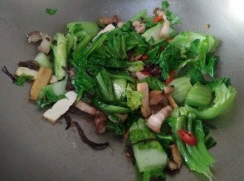 step3: 熱鍋， 倒入橄欖油【得意的一天】， 放入蒜頭爆香，約略1分鐘，等蒜頭香氣出來，再放入三層肉【澎湖豬肉】，蓋鍋蓋，煎約5-10分鐘後，轉中小火續煎，煎至肉香出來，呈現微焦金黃色後，再依序放入木耳、豆干、刈菜、辣椒，少許塩巴，一併炒勻，