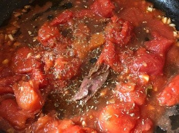 step5: 鑊中放少許油，放入蒜蓉。放入罐頭番茄（Plum Tomatoes）、鯷魚和香草。用慢火邊煮邊按壓直至番茄煮爛，加少量鹽和黑椒調味。