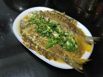 step5: 將黃腳鱲清洗後隔乾水份 , 上少少生粉 , 燒紅油鑊放入黃腳鱲煎封至半熟 , 再放入蒜頭 , 乾蔥 , 薑絲加約 200ml 水 , 糖 , 雞粉 , 黑椒 , 胡椒粉 , 麻油少少生抽 , 蓋好煮約 1 分鐘 , 先將魚上碟魚汁留鑊中 , 再放入蔥花稍為輕炒煮滾 , 再淋上魚身 , 完成 .