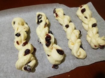 step11: 每份從中間界開，左右手分別向上及下推做成扭紋，然後拿起麵糰的頭端及尾端旋轉幾下再做出大扭紋，放在已鋪上牛油紙的焗盤上，發酵至2倍大。(温度切忌超過30度以免牛油溶化)