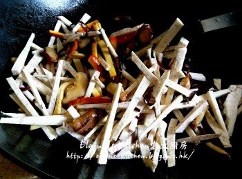 step7: 鑊中加入冬菇絲 , 豆乾條爆至有香味 , 加入芋頭條及木耳絲拌勻