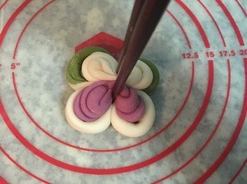 step24: 把捲好的面糰轉個方向，讓捲的地方呈上下的方向，接著再拿筷子，從上下端用力夾緊，此時麵糰會自然的從中間拱起。