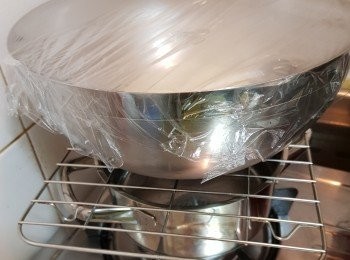 step10: 在另一個乾淨的大碗內，用手塗少許油，放入搓好的<span class="group_3">麵糰</span>，蓋上保鮮紙讓它發酵45分鐘(直至漲大兩倍)。
我多數會煲一煲滾水後熄火待5-10分鐘放涼少許後，煲上放架再放上有<span class="group_3">麵糰</span>的大碗，製做一個較暖的環境讓<span class="group_3">麵糰</span>發酵快些少和好一點。