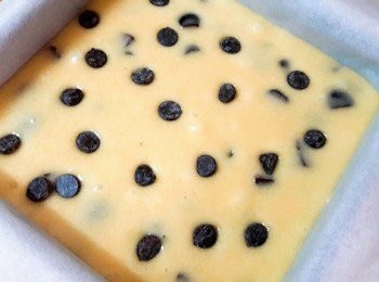 step7: 倒入已用烘焙紙舖好的烤模中 , 再灑一些巧克力粒 , 放入已用170度預熱的烤箱中 , 先烤20分鐘