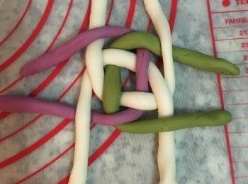 step14: 接著換逆時針方向，把上方的紫薯麵條編到旁邊的牛奶麵條上；下方的牛奶麵糰編到下方的紫薯麵條上；抹茶麵條編到牛奶麵條上；旁邊另一條牛奶麵條再編到上方的抹茶麵條上。