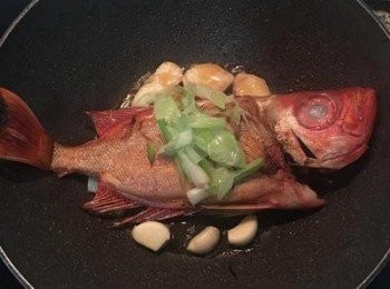 step5: 倒回爆香過的大蔥與蔥白，並將大蒜與薑片下鍋用油煎香。