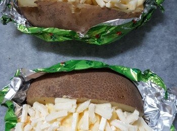 step3: 焗薯包上錫紙，中間界一刀，加鹽同黑胡椒，鋪上蛋沙律同埋芝士碎，焗15分鐘
