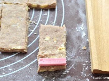 step9: 麵皮前端內捲處包入【<span class="group_2">裹入麵包材料B組</span>】的草莓巧克力磚捲起來