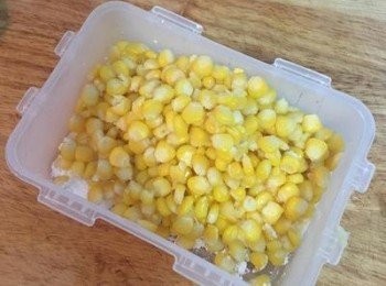 step6: 油鍋加熱；
玉米瀝乾水後，將玉米粒倒入裝有玉米粉的保鮮盒中。