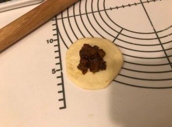 step6: 將麵團輕力壓平(或用木棍擀平），放15g义燒餡在上面，包好，修口向下，放在焗盤上