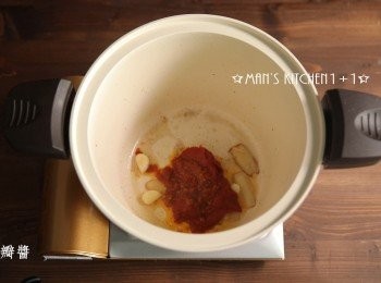 step3: 起油鍋，將蔥、薑、蒜下鍋爆香後，加入番茄膏、辣豆瓣醬炒香。