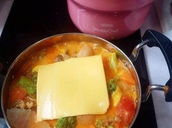 step14: 煮沸後便可以關火，並按個人喜好在內鍋中再鋪上芝士，蓋好蓋子，將鍋移放到Thermos真空煲的保溫容器；繼續燜煮1小時或以上，便可享用。