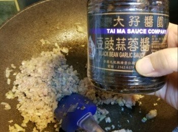 step5: 加入紹興酒略炒，再加入蒜蓉豆豉醬和蠔油炒至熟透，試味後加入葱段炒勻加上茄子上即成