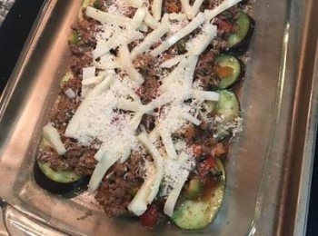 step14: 烤箱預熱到170度；準備好帶深度的烤盤，用廚房餐巾紙抹些橄欖油在烤盤上；先鋪一層茄子片和櫛瓜片，接著舀入牛肉餡，鋪滿在茄子和櫛瓜上；接著撒上馬薩瑞拉起司和帕馬森起司粉；