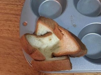 step4: 烤箱預熱到180度；
用餐巾紙在杯子蛋糕模具裡抹點橄欖油或無鹽奶油後，將土司切口上下交叉的塞入模具中，再用桿麵棍將中間壓實。