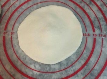 step9: 10分鐘後，從第一顆收圓的先桿，手將麵糰壓扁後，用桿麵棍桿成中間厚，周圍較薄的<span class="group_1">包子皮</span>，一般女漢子會往內桿推後，還沒到中間就會桿壓出來，持續桿ㄧ圈後，翻面擺在旁邊即可；陸續將10顆都桿完（ㄧ樣要記得排順序）。接著將肉餡從冰箱取出，並將蔥花與肉餡拌一下。