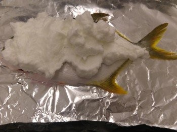 step2: 蛋白液用電動打蛋器打成企身, 然後將粗鹽加入攪勻。 焗盆鋪上錫紙, 將原整表面的黃立䱽放面, 巳打開肚的表面放底。