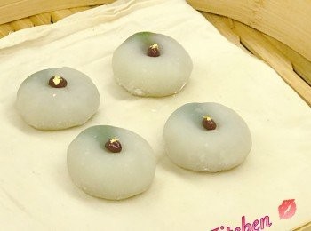 step9: 放紅豆裝飾時， 先用掃把沾上的片栗粉掃走。

再在包好的和菓子頂端， 用手指往中間向下壓， 成一個「lup」放紅豆用， 並加一點金箔裝飾。

完成。