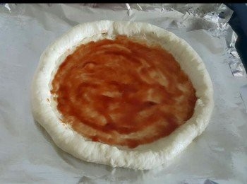 step6: 在麵皮中間抹上茄醬或你喜愛的其他比薩醬， 抹醬後，可以先放一層巴馬臣芝士在上面（也可以不加）。