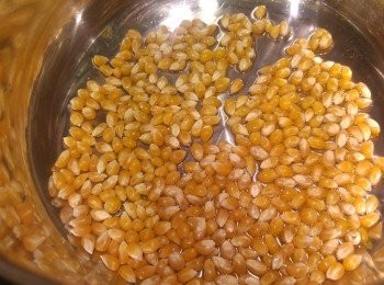 step2: 凍鑊凍油落爆谷粟米粒在燘燒鍋內, 先將油和粟米粒撈混, 鋪平在燘熱鍋內, 之後等待一分鐘後, 蓋蓋先開火焗爆谷, 火力中細火, 電磁爐用3度火。