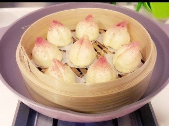 step8: 趁壽包還熱，用刮板在包底中間向內壓出一條桃分線。

加少量水把紅麴粉開稀，然後用牙刷沾上紅麴水，並輕輕彈上壽包頂端範圍，裝飾一下。