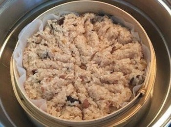 step13: 大蒸鍋此時可以開始將水煮滾， 容器的竹製蒸籠裡鋪上蒸籠紙或布，略微用水噴濕，鋪上炒好的糯米飯，鋪平後用飯匙略微切一些凹痕.方便均勻受熱；放入大蒸鍋中,大火蒸15分鐘。