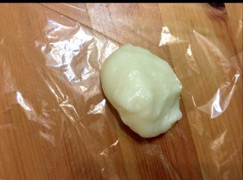 step5: 戴上膠手套，鋪上保鮮紙在桌上，放上40g糯米糰，再糯米糰上蓋上保鮮紙，用棍滾平至手掌心咁大。