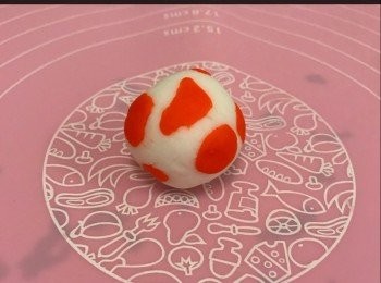 step7: 將餘下18克皮搓圓， 然後把2克紅色皮再分小圓， 隨意放在白色皮的周圍， 再搓圓。