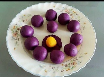 step2: 做法
 紫蕃薯去皮切件，蒸8-10分鐘直至軟身。把紫蕃薯壓成蓉，先加入一半分量的糯米粉拌勻，然後再加餘下糯米粉再攪，（根據蕃薯蓉的濕度而決定是否需要加入小許麵粉），再加入油及糖拌勻
用手搓粉糰至順滑不黏手，然後分成球狀(約12份左右)。將奶皇放入紫薯蓉，再搓圓後放上碟