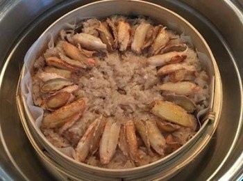 step14: 15分鐘後打開,檢查是否糯米已蒸熟,試出如有夾生則請在表面噴些水後再蒸10-15分鐘；女漢子這次米炒的夠，所以蒸第一個15分鐘後就已經差不多全熟了；確定糯米飯沒有夾生之後就可以排入之前炒好的蟹肉和薑片，中間再擺上少許的紅蔥酥增加香氣。