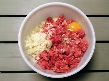 step3: 將攪碎肉類放入盤中，加入麵包糠牛奶、雞蛋及洋蔥，再加入鹽及黑椒<span class="group_4">調味料</span>。用手攪拌至黏狀。