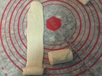 step12: 取第一個捲好的，放直；用橄麵棍從中間輕壓後分別向上及向下桿開桿薄成長條狀。輕推捲起；再一次依續排好。