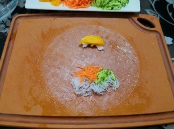 step4: 在下方約1/3位置放上粉絲／青瓜絲／甘筍絲  ;  在上放約1/3放上芒果片及蝦仁（請參考照片）