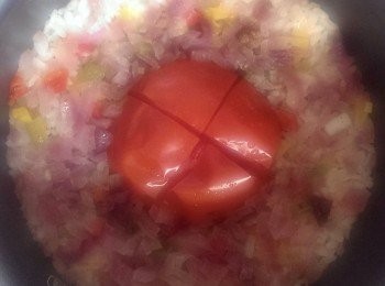 step2: 番茄去蒂，於底部刀割十字，置於飯鍋中間。
按下煮飯模式，待飯熟後，趁熱加入橄欖油將所有材料拌勻即可享用。