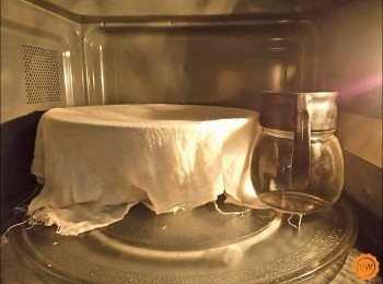 step4: 進行發酵（基發至少需要60分鐘)：取一鋼盆內部抹上一點沙拉油防沾黏之後，將揉至三光的麵糰，收集成圓，收口面朝下的方式放入鋼盆，再蓋上一塊濕布進行發酵。放入家裡微波爐，在鋼盆的一邊再放上一壺燒開冒著蒸汽的滾水，關上微波爐的門，就可以達到理想的麵糰發酵環境。