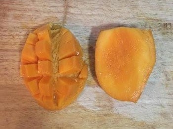 step15: 芒果切取左右兩邊，於芒果肉上劃刀，將皮往前頂後，芒果肉便會完全突起，方便切割。