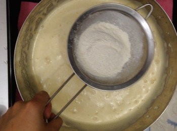 step7: 拿走熱水，篩入高筋麵粉，用手動打蛋器輕拌至完全沒有粉粒