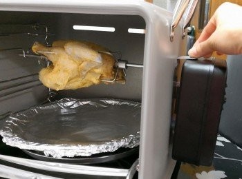 step5: 用錫紙將烤蒸寶的上層焗碟包好再放在特定位置;  將雞放在旋轉燒烤叉的位置; 安上旋轉摩打