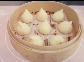 step7: 把每份麵團壓成中間厚旁邊薄的麵皮,包入蓮蓉餡，收口向下放上烘焙紙上， 把包的頂部收尖成桃形。

用水溫約35-40度放於鑊內， 再把整盤蒸籠的壽包，連蓋放上去，待發酵15-20分鐘左右。

跟著用中小火蒸20分鐘，完成後先打開少少蓋疏氣5分鐘才取出。