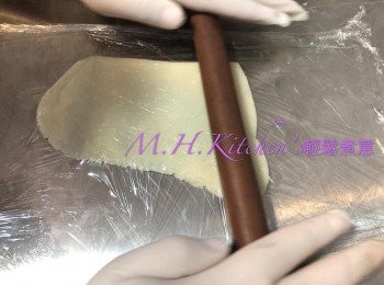 step17: 取出待微暖後的粉糰，戴上手套搓揉粉糰至光滑，取個人喜好大小，放於底面二層的保鮮紙 中間，用木棍推開平均厚度