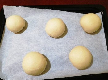 step2: 取出麵糰回溫，排氣、翻面滾圓並分成10份，每份包入量肉鬆，收口向下，放上焗盤及蓋上保鮮紙待發酵至2倍大(約1小時)。