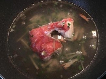 step4: 接著放入鹽、胡椒粉後，將魚頭、魚塊放入，並倒入米酒ㄧ起煮滾；試湯的鹹度做調整，大滾後放入蔥花並灑些香油，即可起鍋享用。